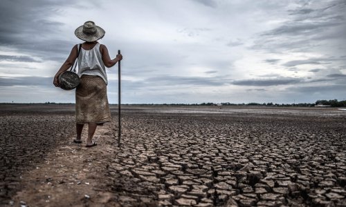 Women standing on dry soil and fishing gear, global warming and water crisis